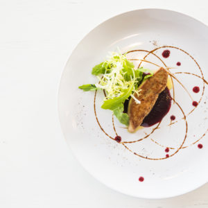 Grilled foie gras with sweet sauce in white dish - selective focus point